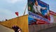 A North Korean woman walks past the outer wall of a construction site where a propaganda billboard depicting the launch of North Korean rockets in Pyongyang, North Korea. The billboard reads: "Lets open up an era to a strong economic country."