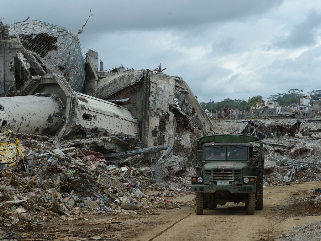 A military truck drives past the rubble of a bombed-out mosque in what was the main battle area in Marawi on the southern island of Mindanao in the Philippines on Oct. 25, 2017, days after the military declared over the fighting against Islamic-State