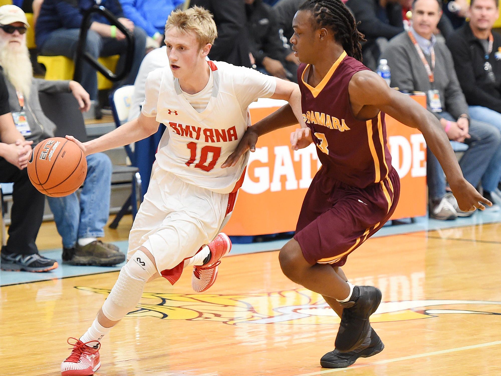 Smyrna's #10 Caleb Matthews drives for the basket as The Annual Slam Dunk to the Beach Basketball Tournament started at Cape Henlopen High School in Lewes on Tuesday December 27th with Smyrna HS (white) hosting Bishop McNamara HS from Forestville, Md.