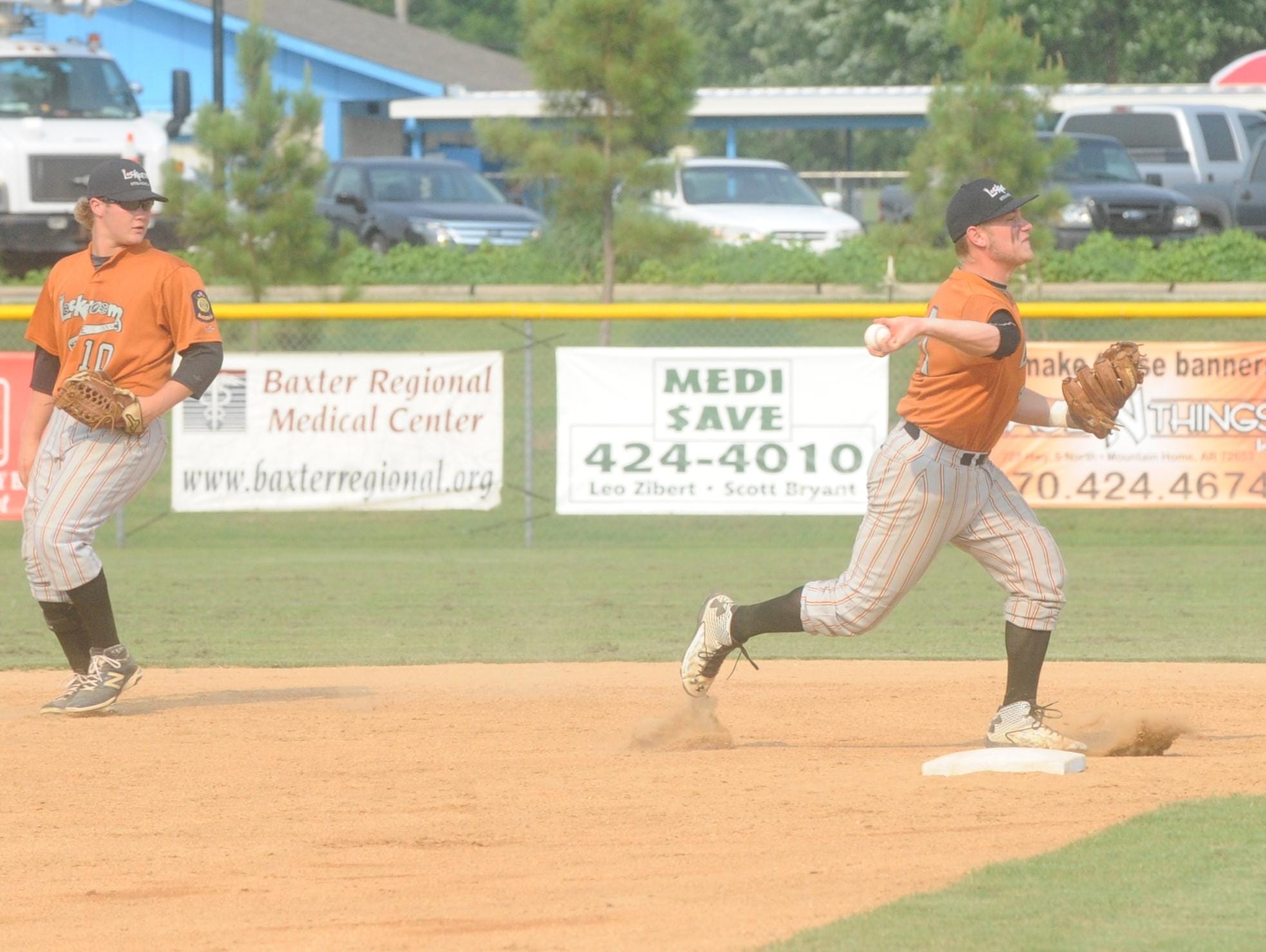 Lockeroom shortstop Hayden Hall, right, throws to first for an out during Mountain Home’s 8-1 victory over Batesville on Tuesday at Cooper Park. Also pictured is second baseman Matt Robbins.