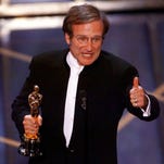 Robin Williams accepting his Oscar for Best Supporting Actor at the 70th Annual Academy Awards at the Shrine Auditorium in Los Angeles.