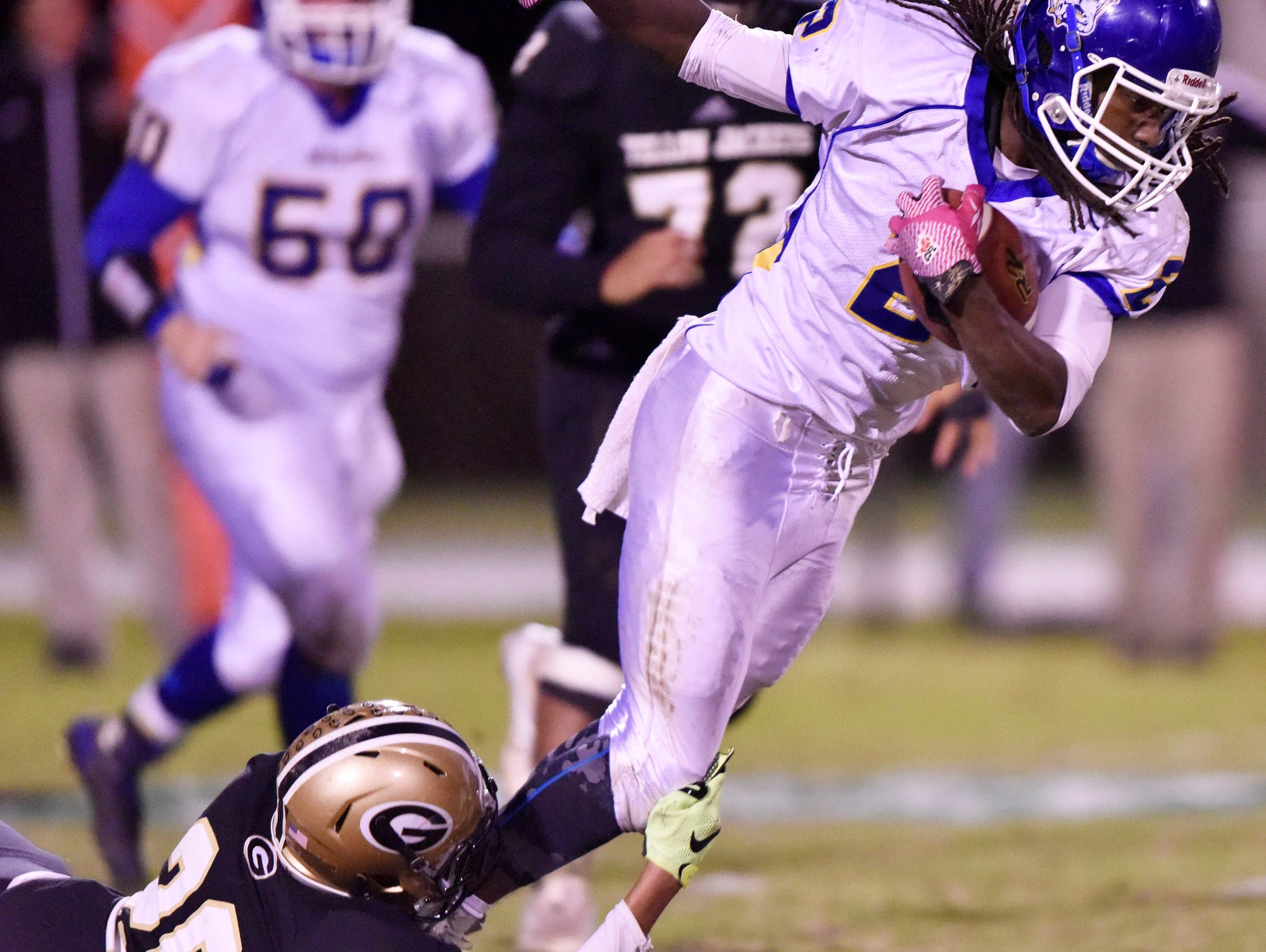 Travelers Rest's Xaiver Terry (2) is caught by Greer's D.J. Sitton (20).
