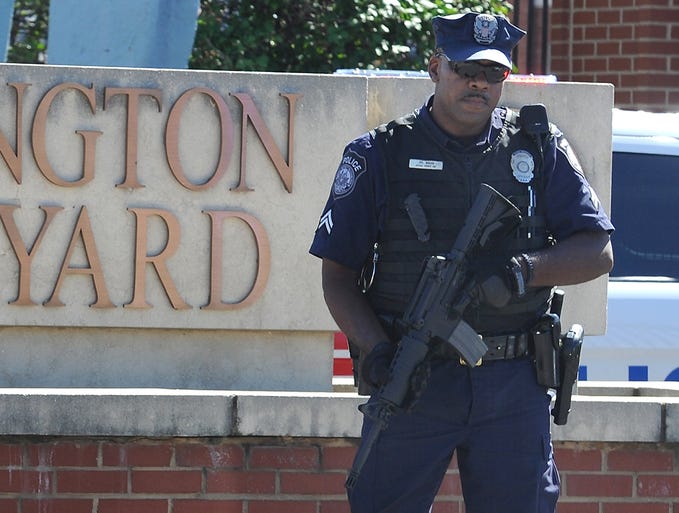A guard stands outside the gate to the Washington Navy Yard on Sept. 17 in Washington, D.C. Thirteen people, including the gunman, were killed during a shooting at the facility a day earlier.