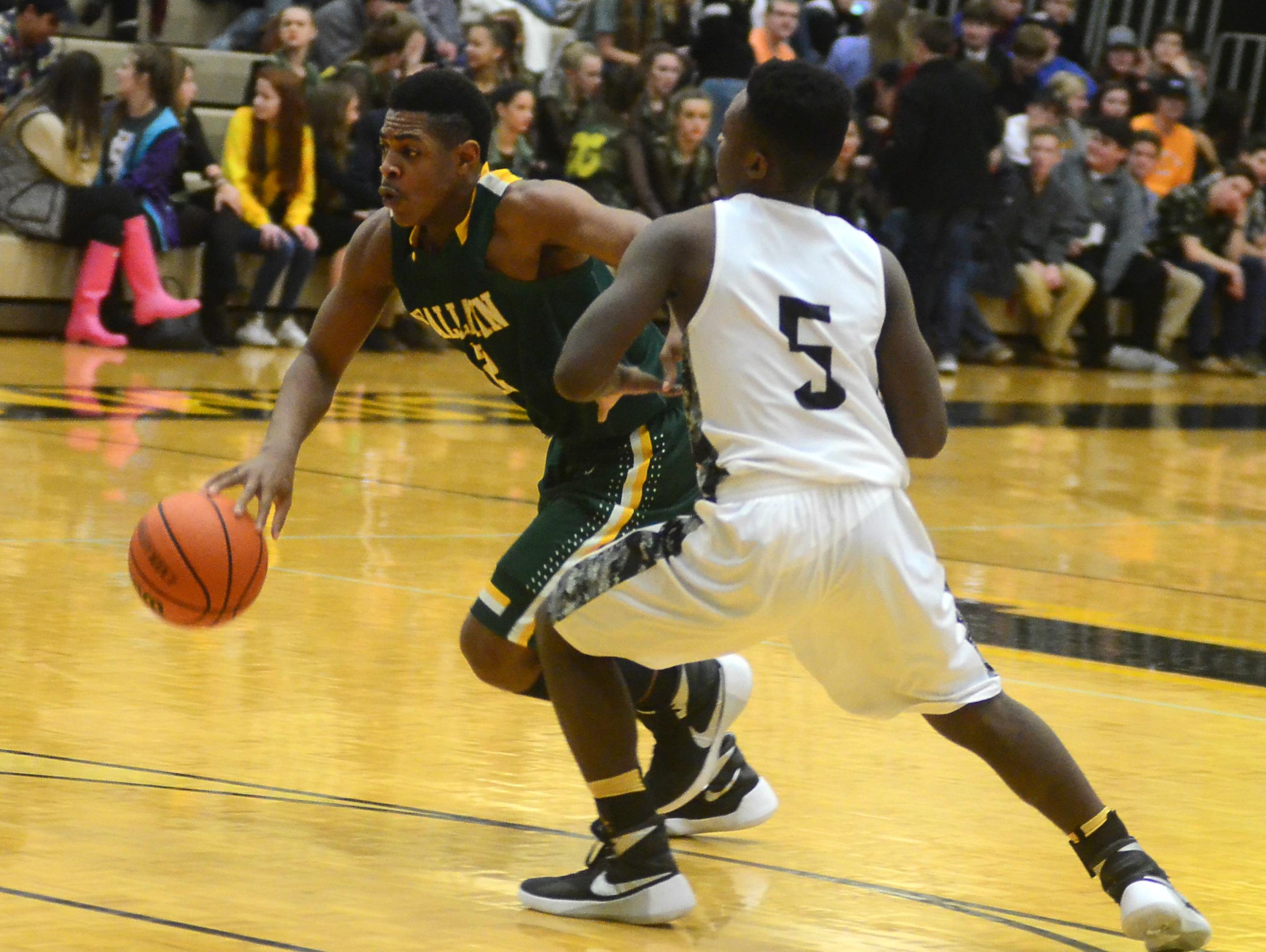 Gallatin High sophomore guard Zyun Mason dribbles into the lane as Hendersonville sophomore Dyilin Hoosier defends during third-quarter action. Mason scored 15 points in the Green Wave’s double-overtime win.