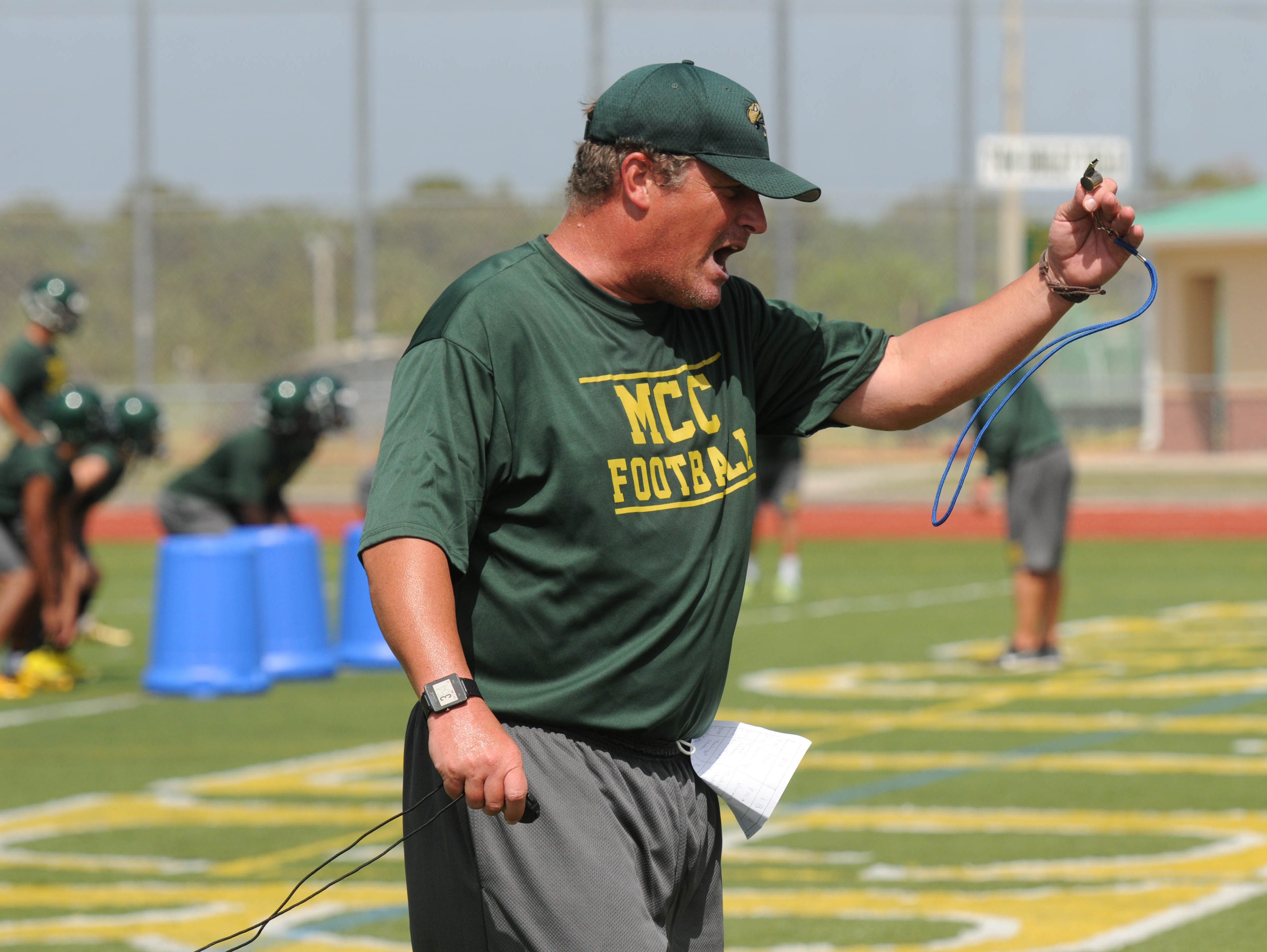 Melbourne Central Catholic football coach Stacy Sizemore encourages his players during practice Tuesday afternoon.