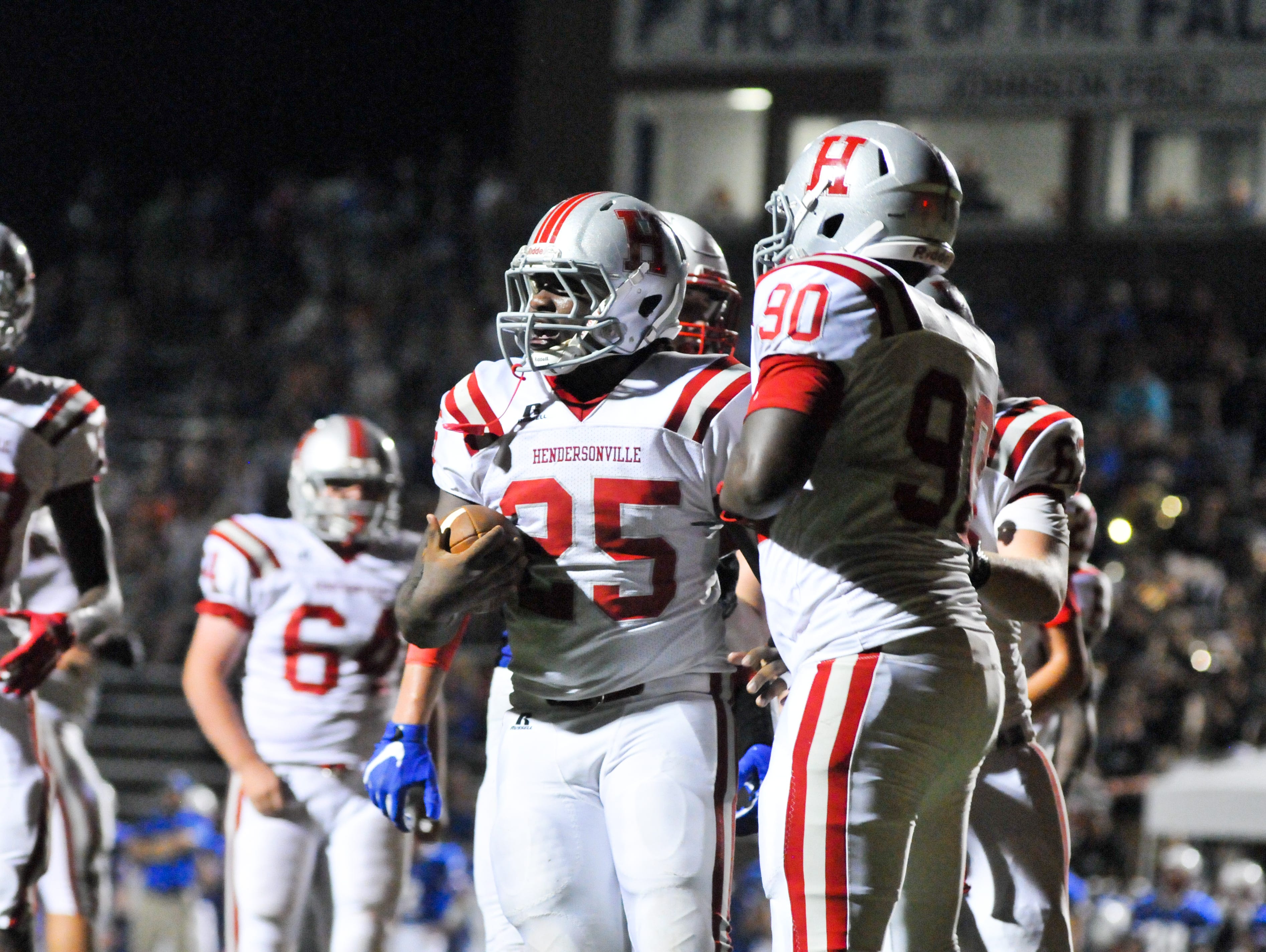 Ty'rese Hunt (25) is congratulated by teammate Tyrese Cauley after scoring a touchdown Thursday at West Henderson.