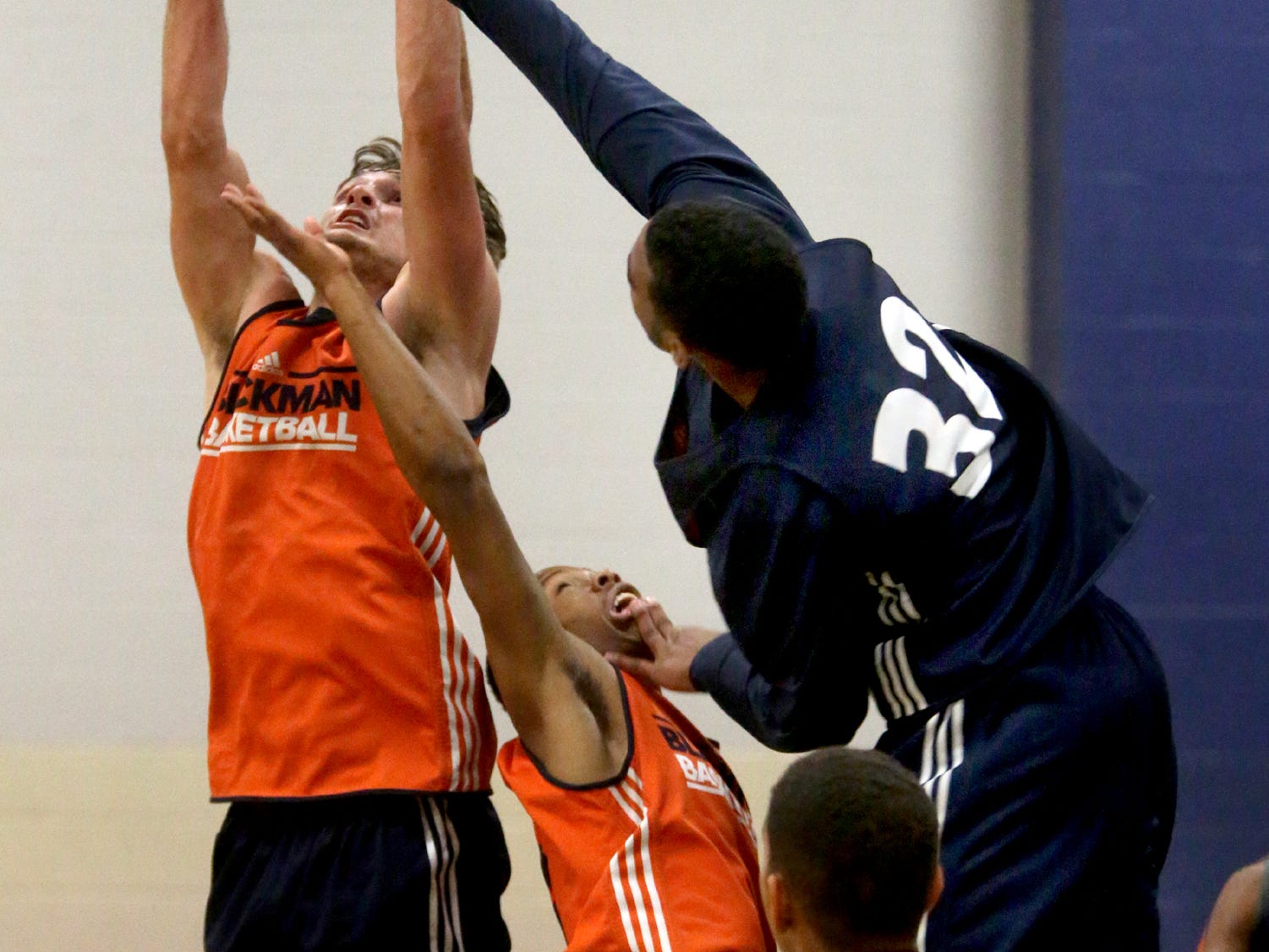 Blackman boys basketball players Christian DeWitt, Isaiah Hart and Jacob Nelson go up for a rebound during the team’s first day of practice on Monday.