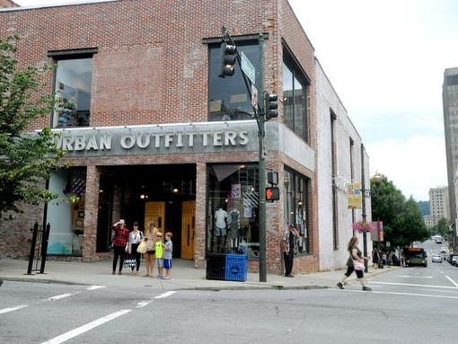 Pedestrians walk past the Urban Outfitters at College