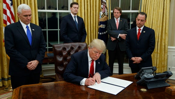 President Trump signs his first executive order on