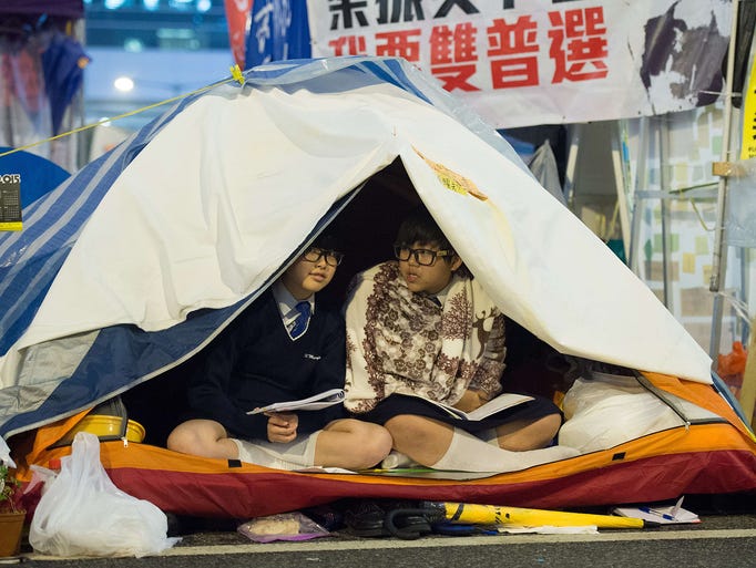 Students read books in their tents at the pro-democracy