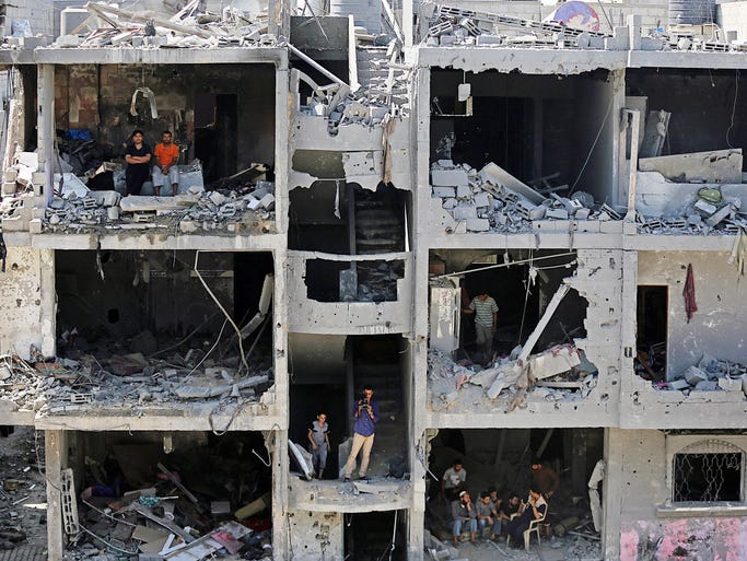 Palestinians sit on rubble of houses destroyed after Israeli airstrikes in Rafah, southern Gaza Strip.