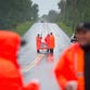 Corrections officers stand along a road before searching a residential area on Sunday in Malone, N.Y.