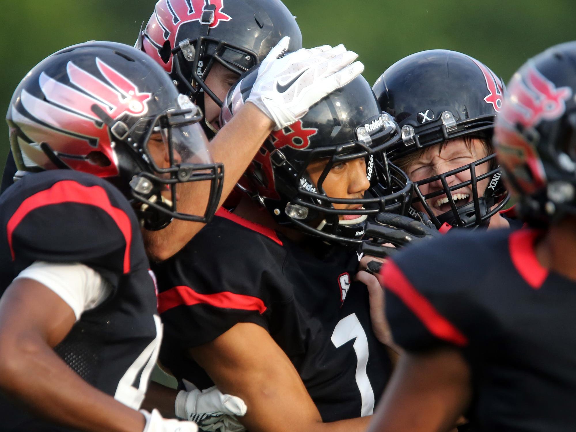 Stewarts Creek football players congratulate teammate Cynterius Lyons for an interception against Blackman during the first Jamboree game Friday Aug. 14, 2015, at Stewarts Creek.