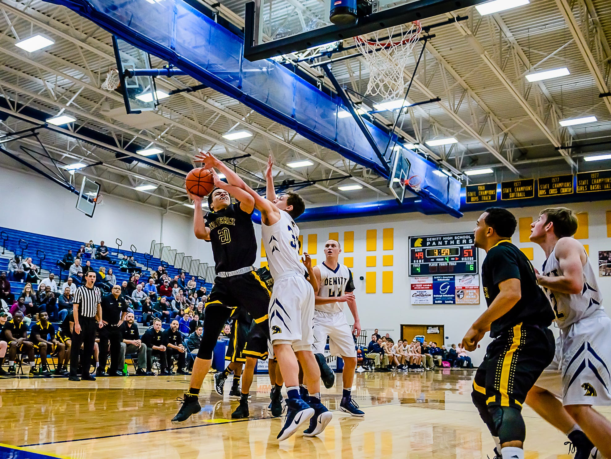 Tevin Ali ,left, of Waverly is fouled by Luke Hyde of DeWitt during their game Friday January 6, 2017 in DeWitt. KEVIN W. FOWLER PHOTO