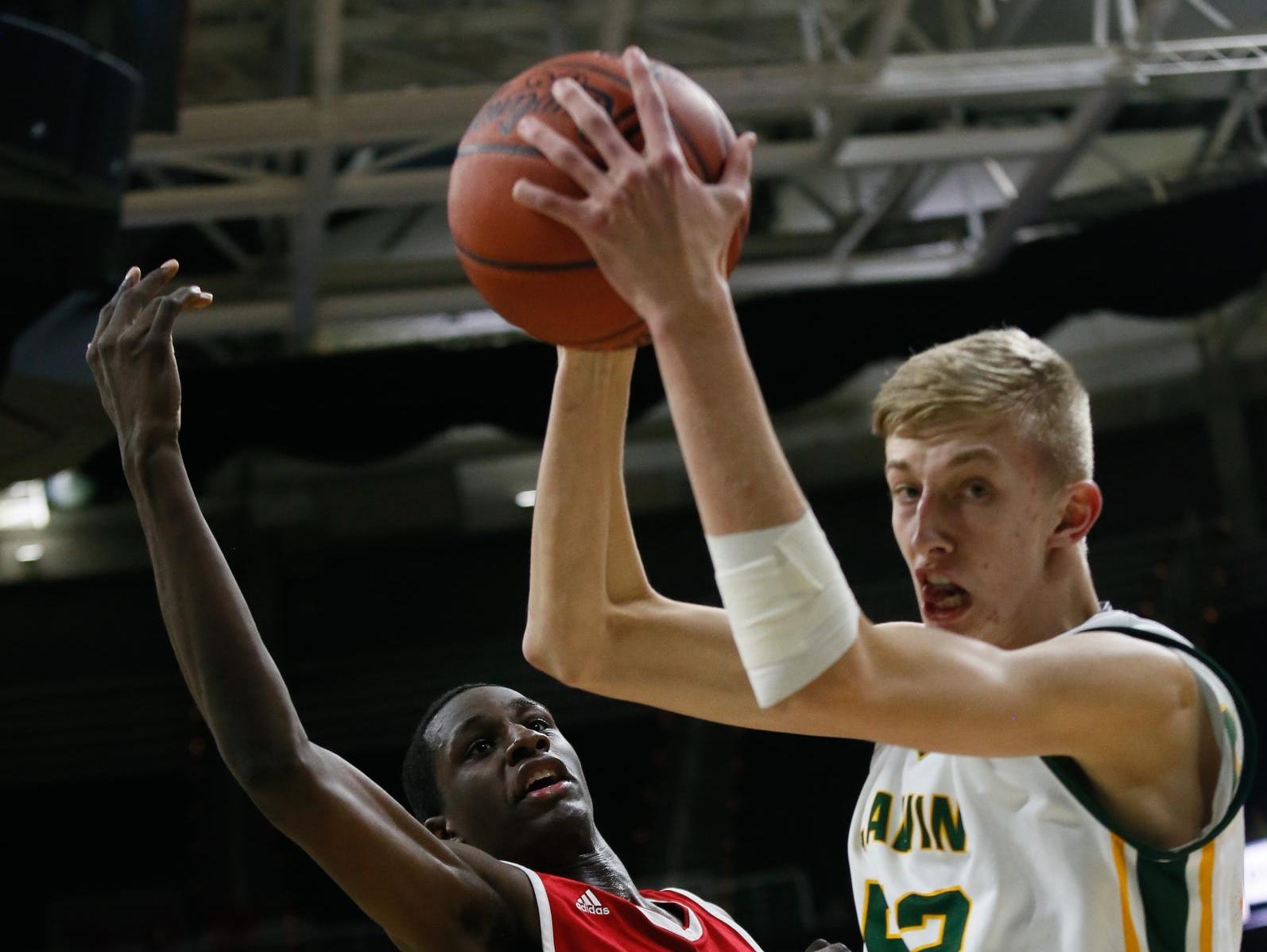 Flint Beecher's Levane Blake battles for a rebound during the Class C state championship game Saturday with Grandville Calvin Christian's Blake Verbeek. Blake hit a free throw and made a key block in the final minute, while Verbeek scored a game-high 22 points.
