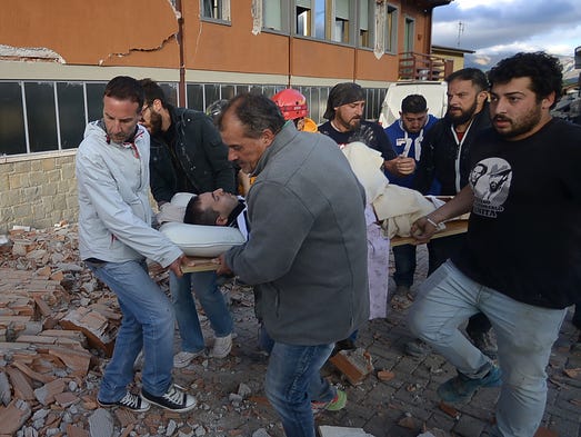 Residents carry an injured victim from a damaged building