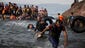 Migrants arrive on a dinghy after crossing from Turkey