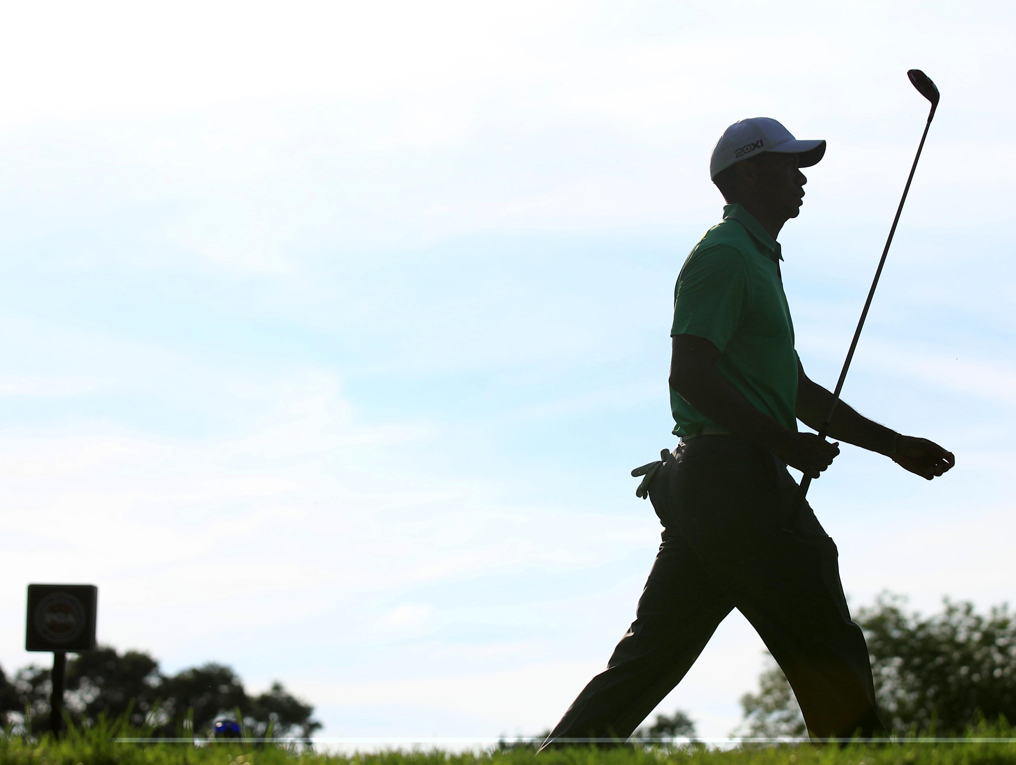 Tiger Woods walks off the 10th tee during Friday's second round of the 95th PGA Championship. Woods finished with an even par 70 to keep him at plus 1, eight strokes behind leader Jason Dufner's minus 9.