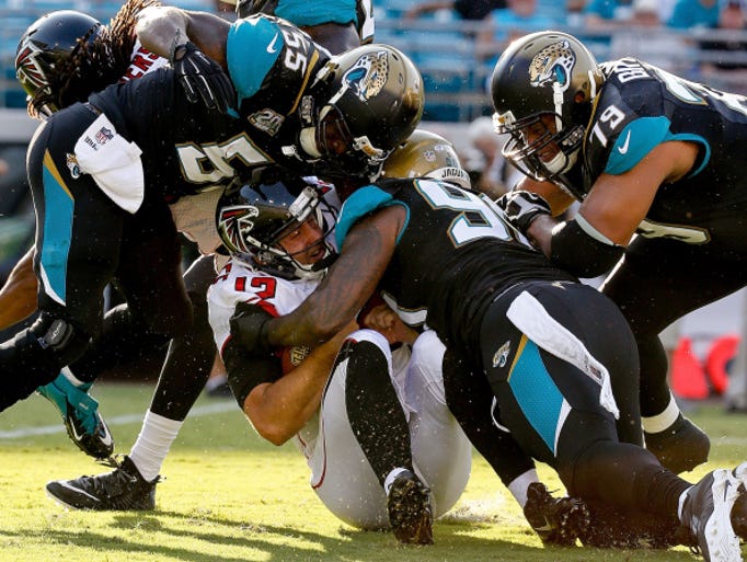 JACKSONVILLE, FL - AUGUST 28: Sean Renfree #12 of the Atlanta Falcons is sacked by Andre Branch #90 of the Jacksonville Jaguars during the first half of the game at EverBank Field on August 28, 2014 in Jacksonville, Florida. (Photo by Rob Foldy/Getty Images)