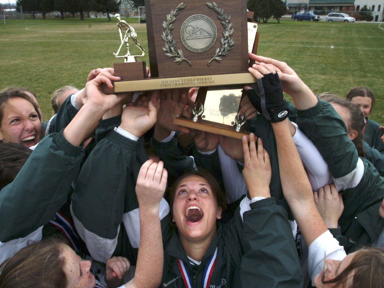 Stowe High School’s Madison Ross (center) holds the girls Division III field hockey championship trophy after the Raiders won the 2004 title.