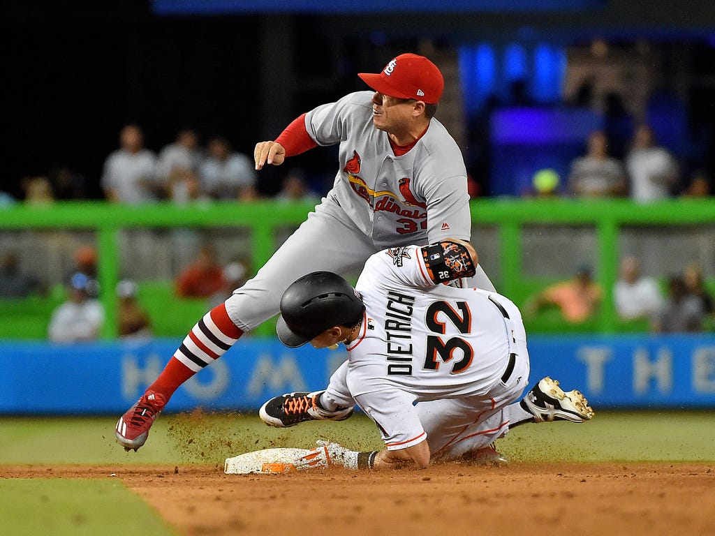 St. Louis Cardinals shortstop Aledmys Diaz tags Miami Marlins third baseman Derek Dietrich for an out in the fourth inning at Marlins Park in Miami.