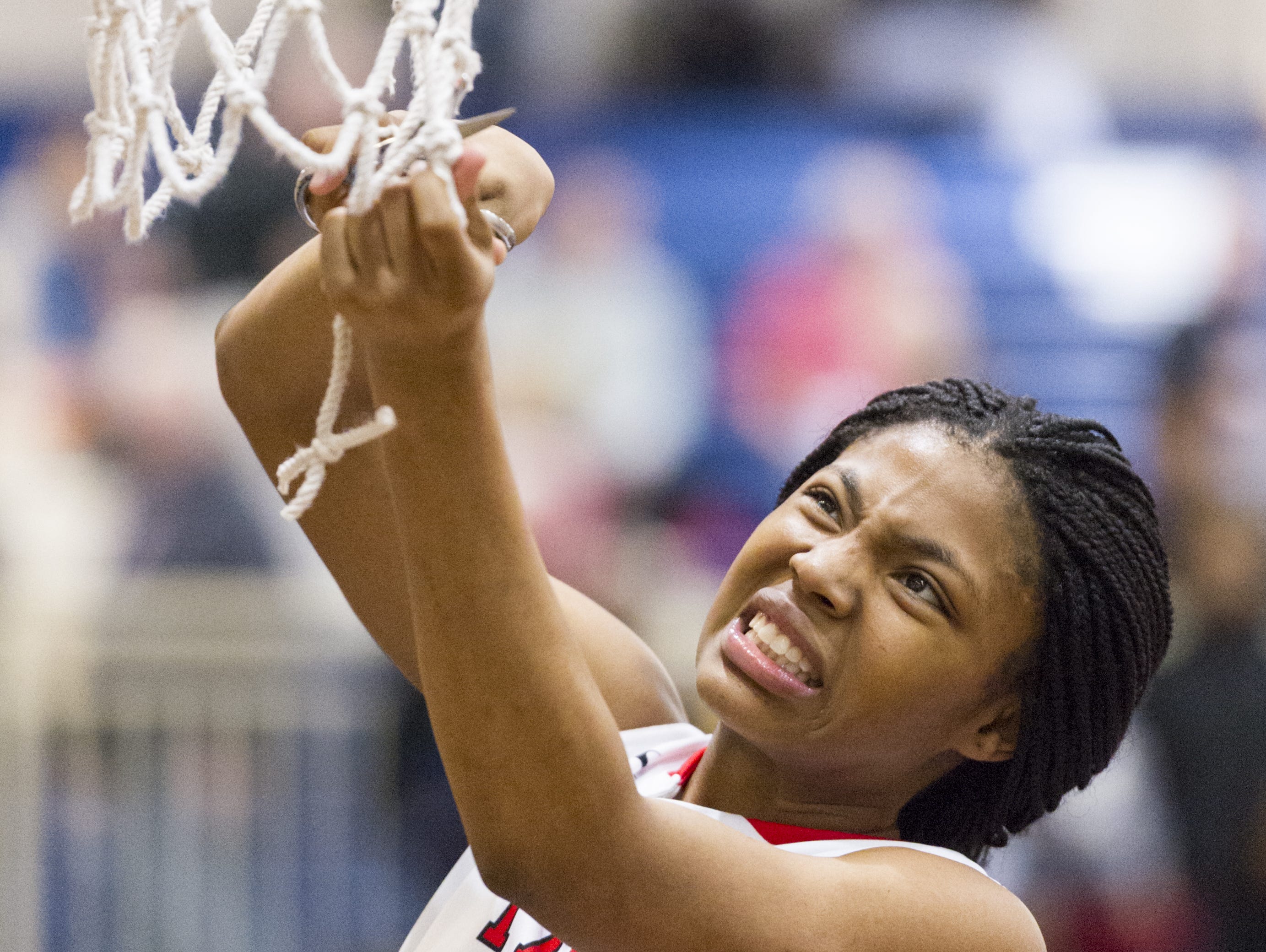 Pike High School junior Angel Baker (15) grimaces as she struggles to cut down a piece of the game net after winning the IHSAA 4A Girls' Basketball Tournament Regional championship game, Saturday, Feb. 11, 2017, at Decatur Central High School. Pike won in overtime, 61-59.