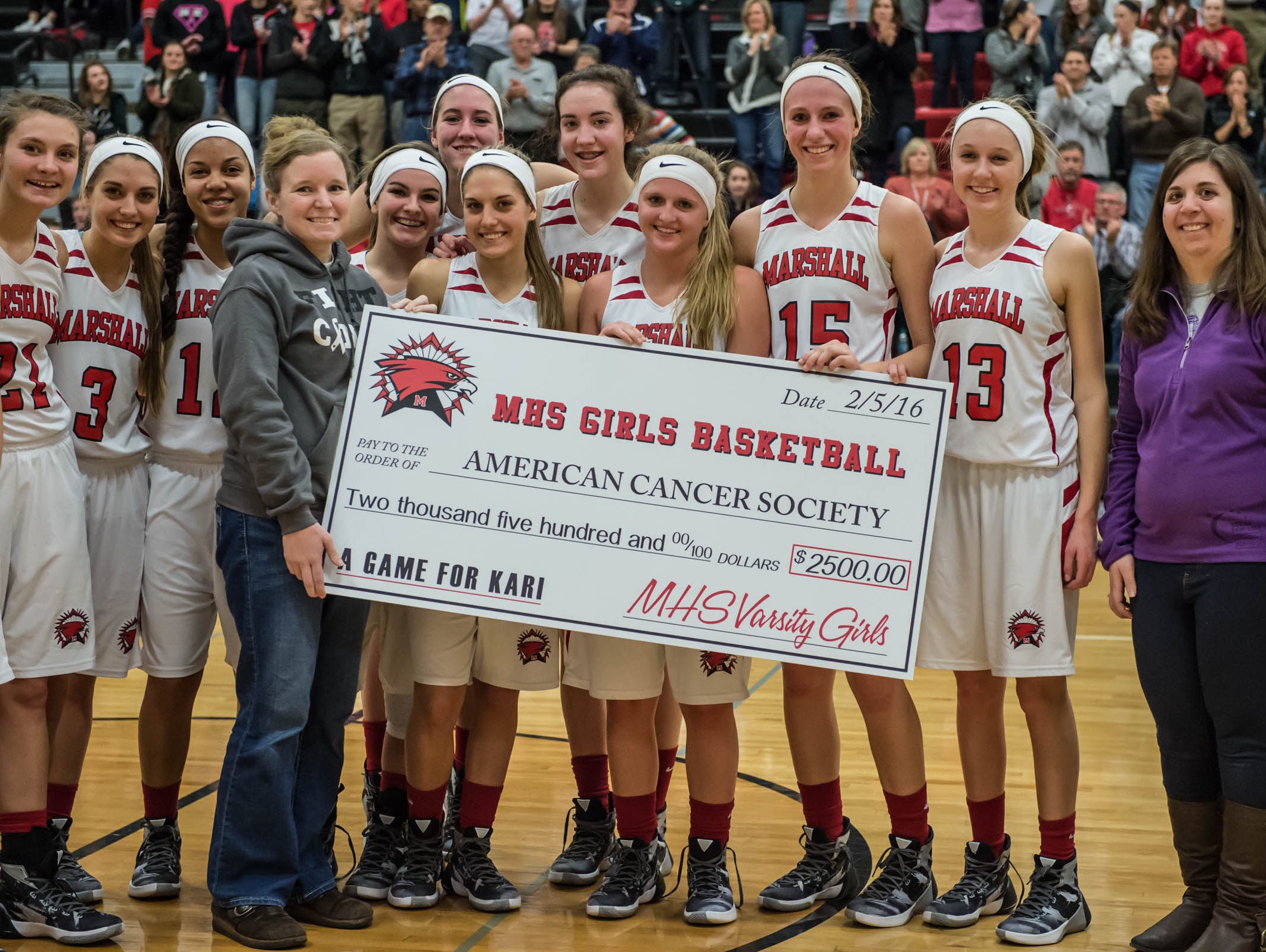 Kari (Searles) Jolink helps present a check to the American Cancer Society on Friday.