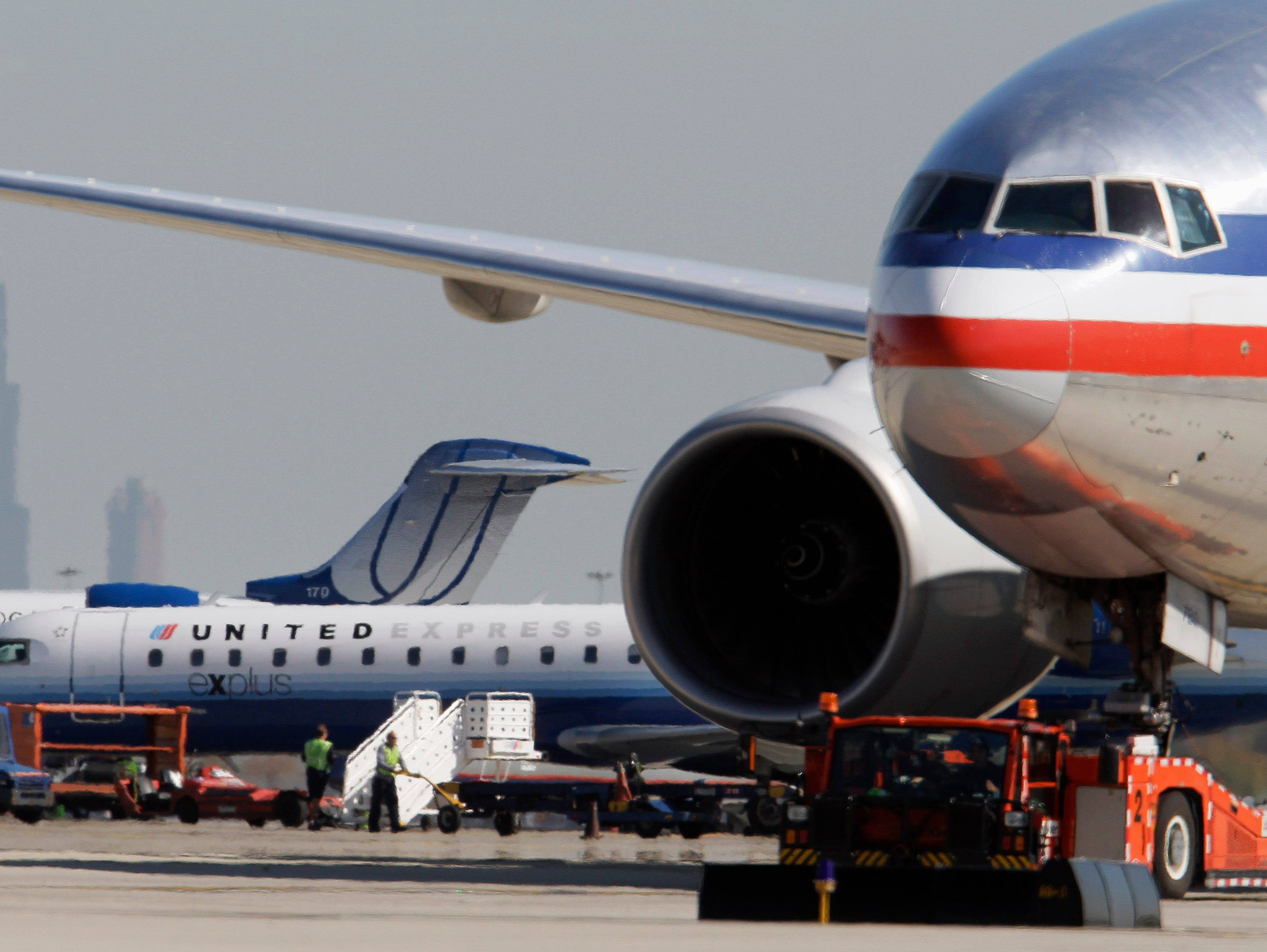 In this photo from Oct. 5, 2010, an American Airlines jet, right, taxis past United Airlines and United Express jets at O'Hare International Airport in Chicago.