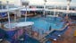 Norwegian Getaway's main pool is flanked with two covered hot tubs, and there are two more hot tubs nearby.
