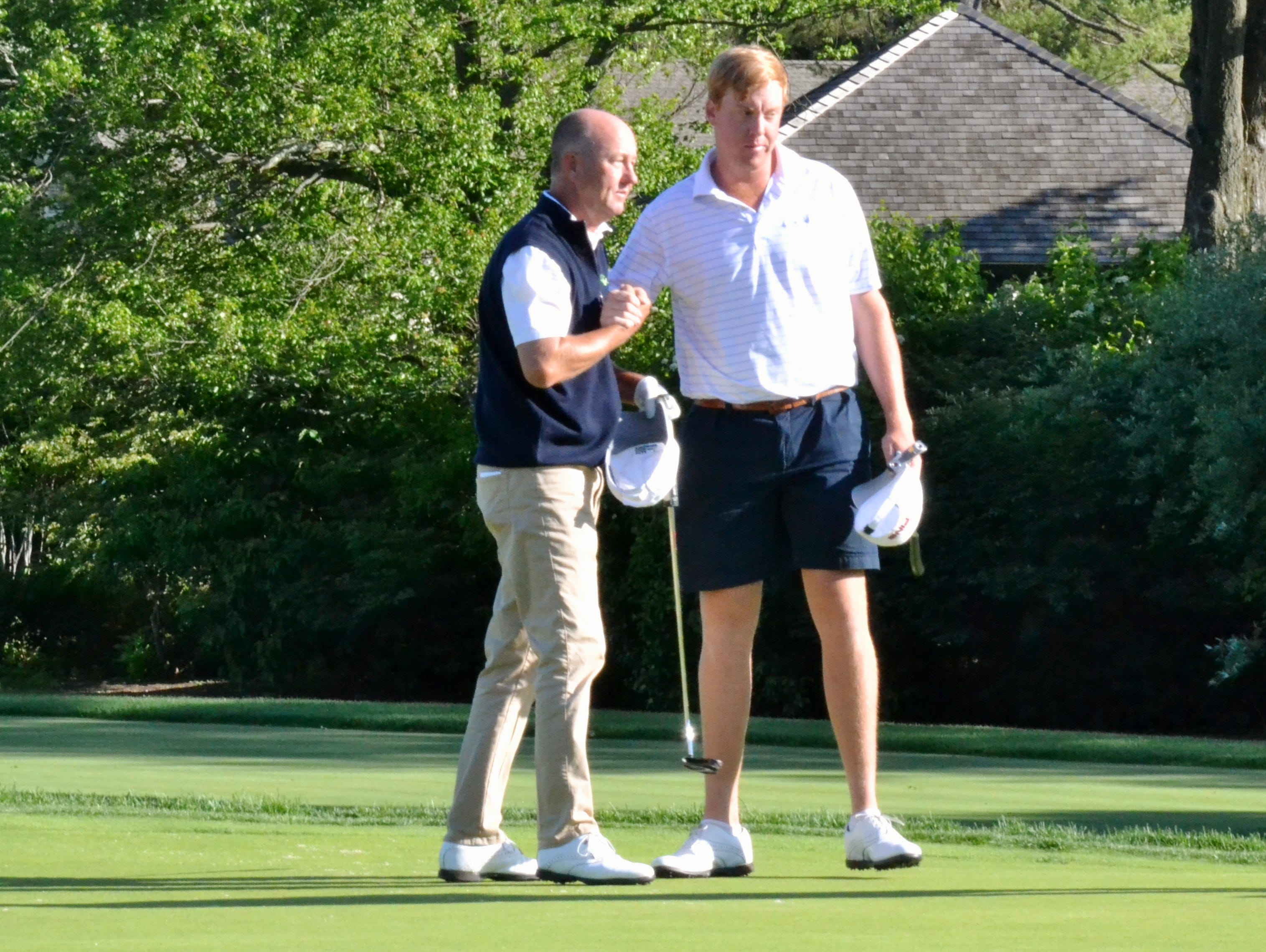 Mark Love and Dru Love shake hands after shooting a 75 on Thursday in the opening round of the Anderson Memorial at Winged Foot