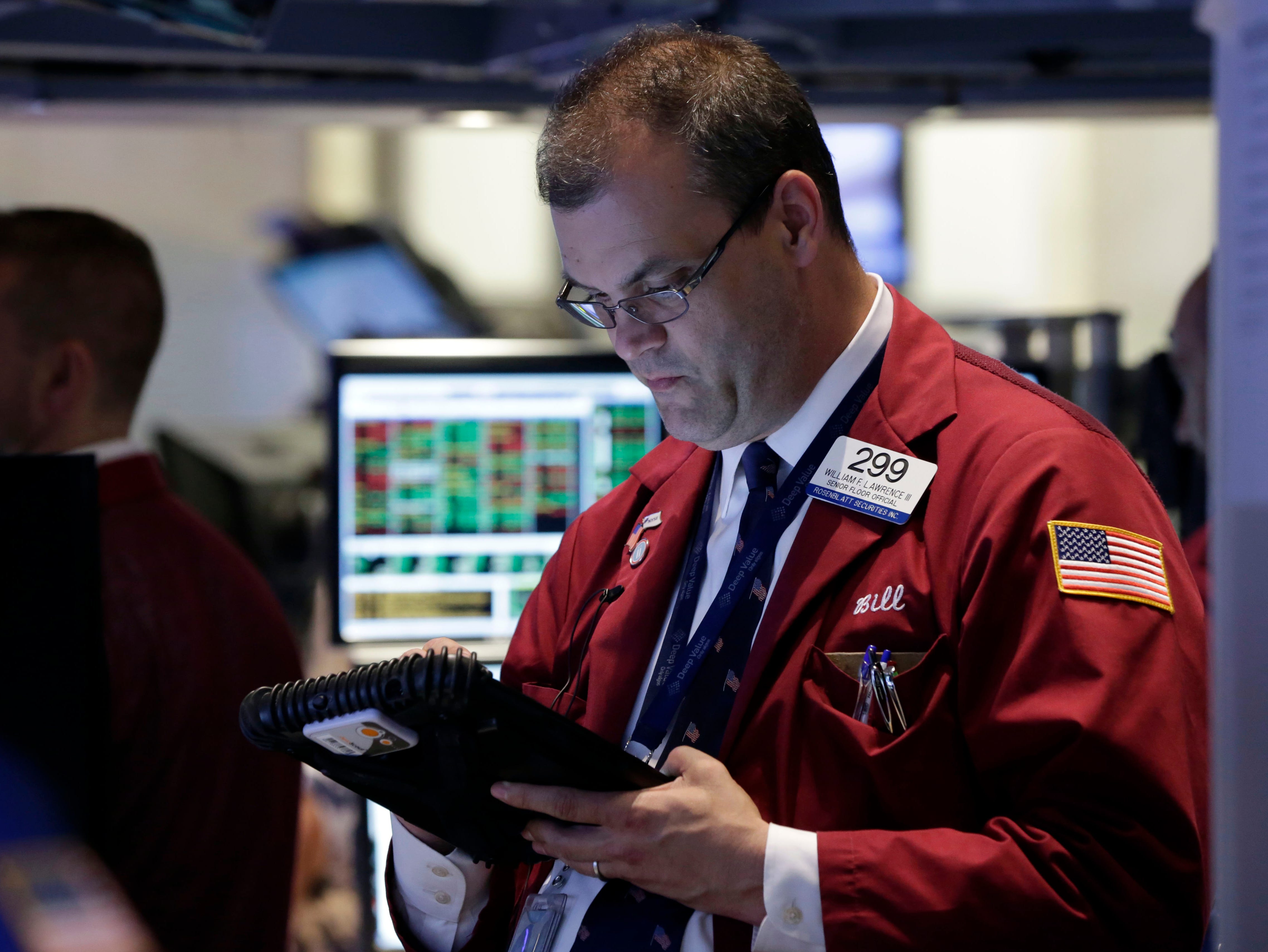 Trader William Lawrence, right, works on the floor of the New York Stock Exchange Wednesday.