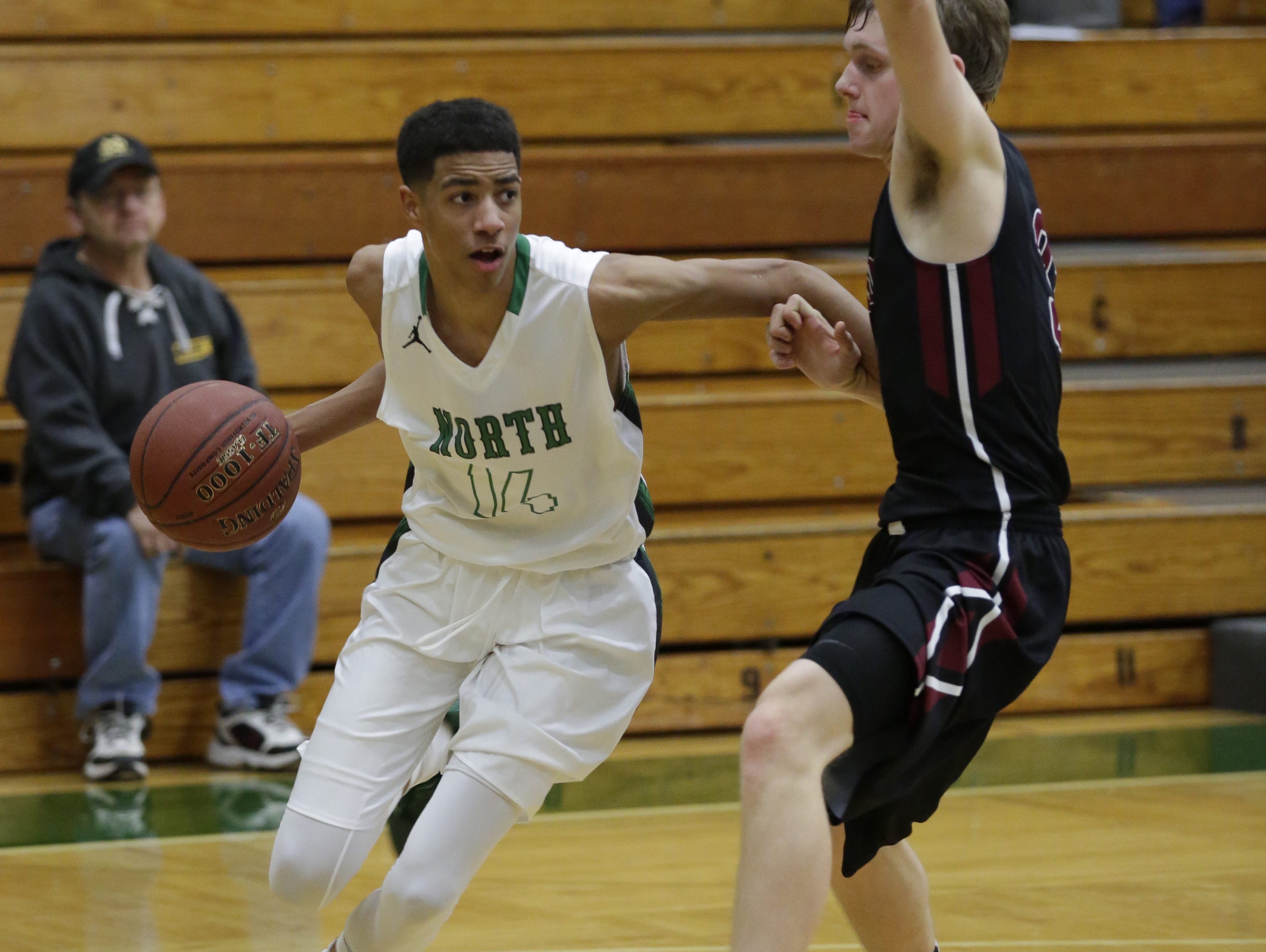 Oshkosh North's Tyrese Haliburton dribbles around a Fond du Lac player during Thursday's game.