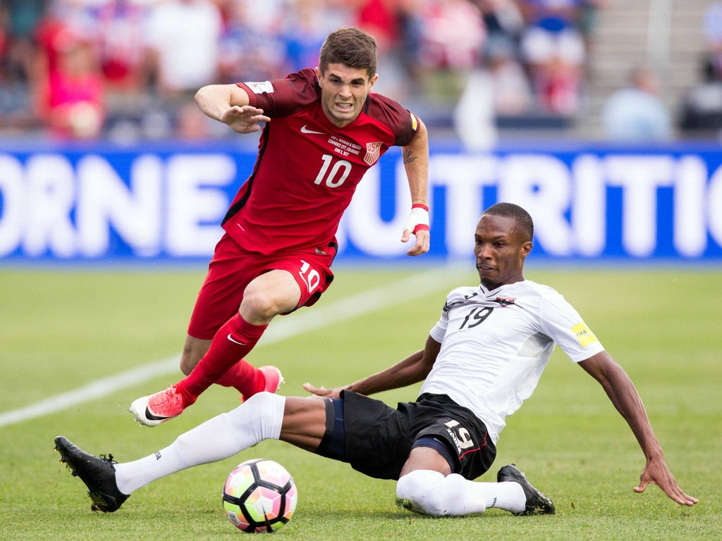 Trinidad & Tobago midfielder Kevan George defends against United States midfielder Christian Pulisic, left,  in the first half at Dick's Sporting Goods Park in Commerce City, Colo.