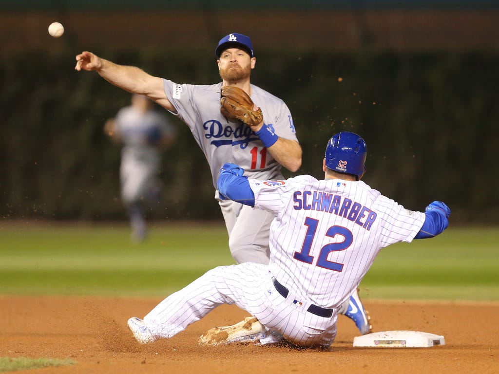 Los Angeles Dodgers second baseman Logan Forsythe forces out Chicago Cubs left fielder Kyle Schwarber on a fielders choice in the 6th inning in game five of the 2017 NLCS playoff baseball series at Wrigley Field in Chicago.