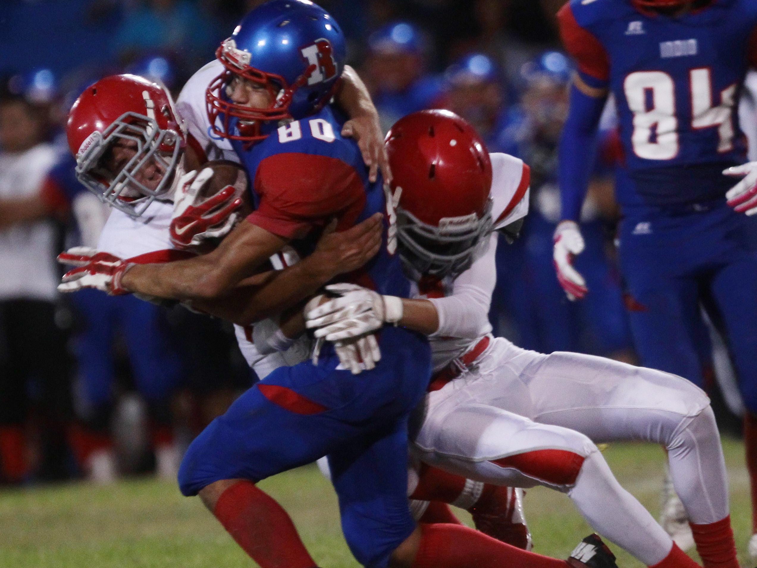 From Left, Desert Mirage High School defenders Jaime Serrano and Dylan Arreola take down Indio High School's Brian Cervantes at Ed White Stadium in Indio on August 28, 2015.