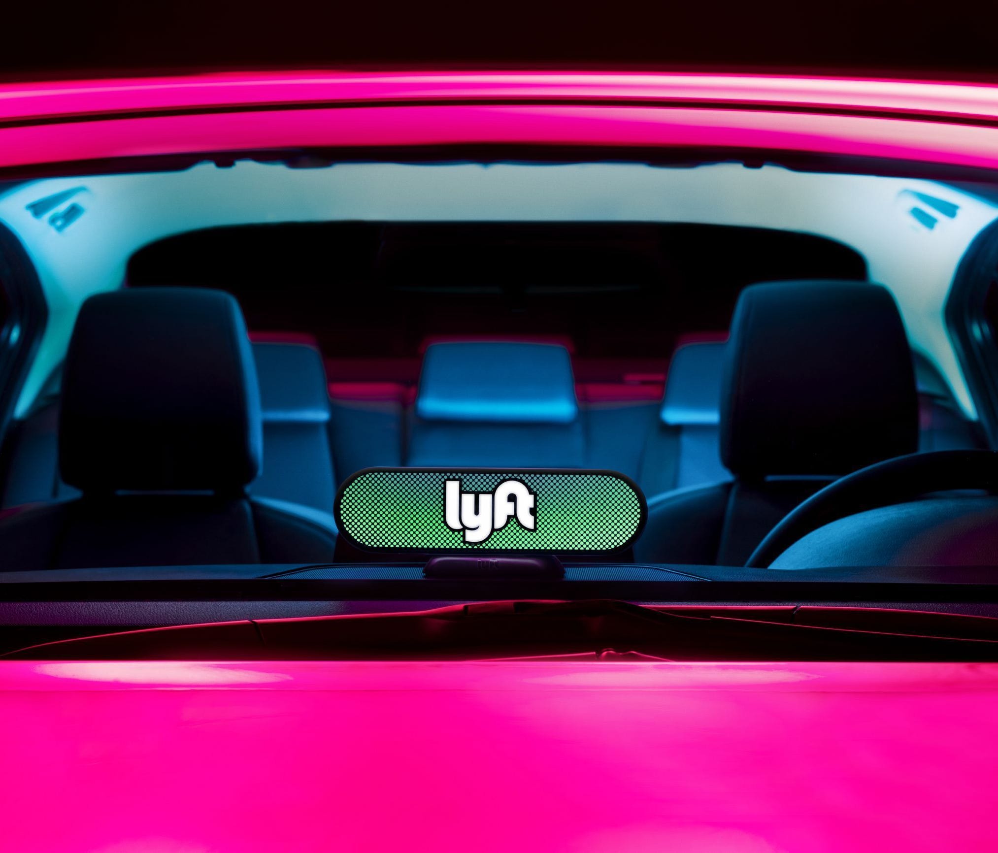 Lyft's new Amp device sits on the dashboard of a vehicle, replacing the company's signature pink Glowstache.