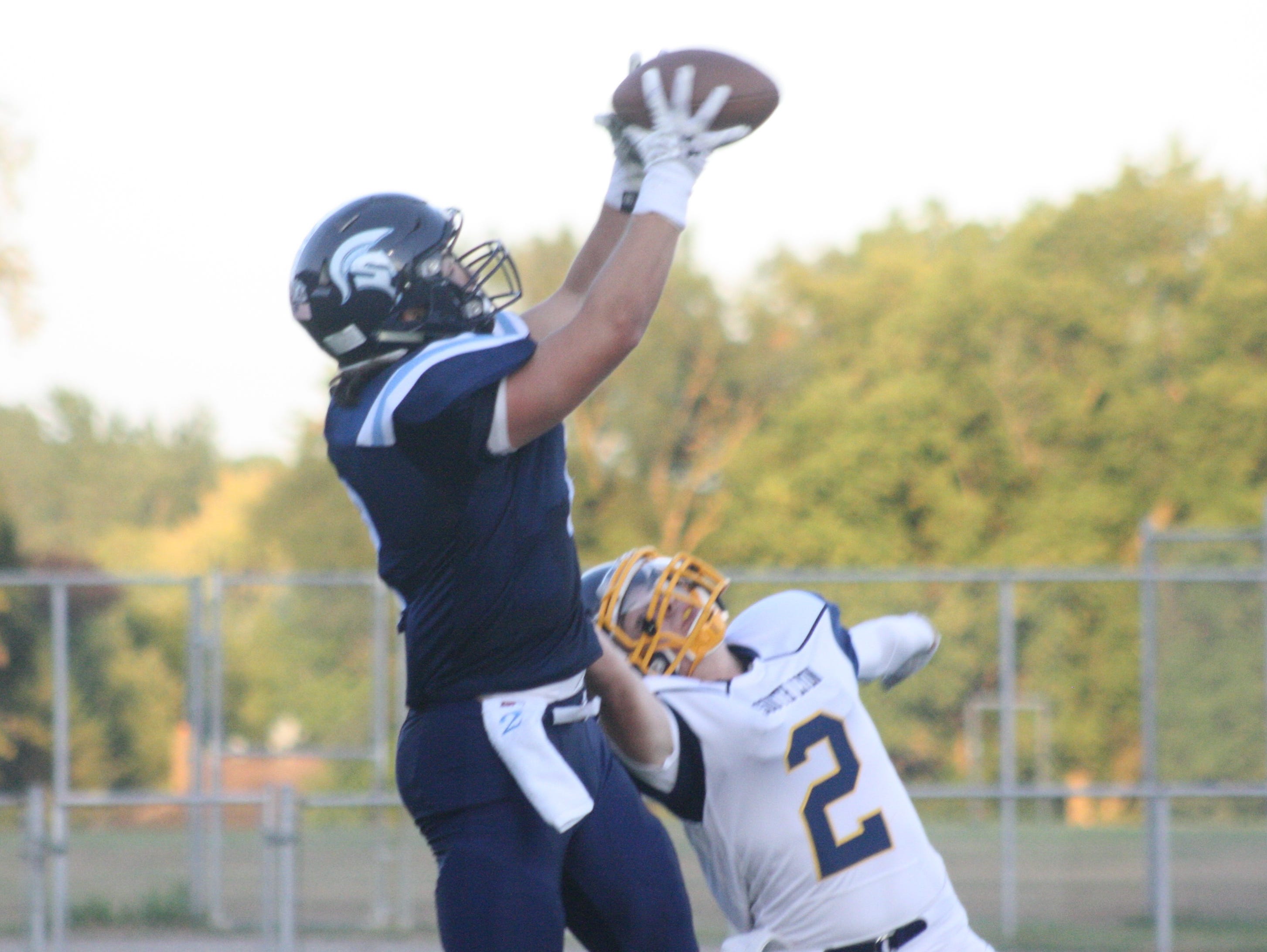 Livonia Stevenson's Austin Petries hauls in a touchdown pass from Chris Tanderys 20 seconds into Friday's 35-0 victory over South Lyon.