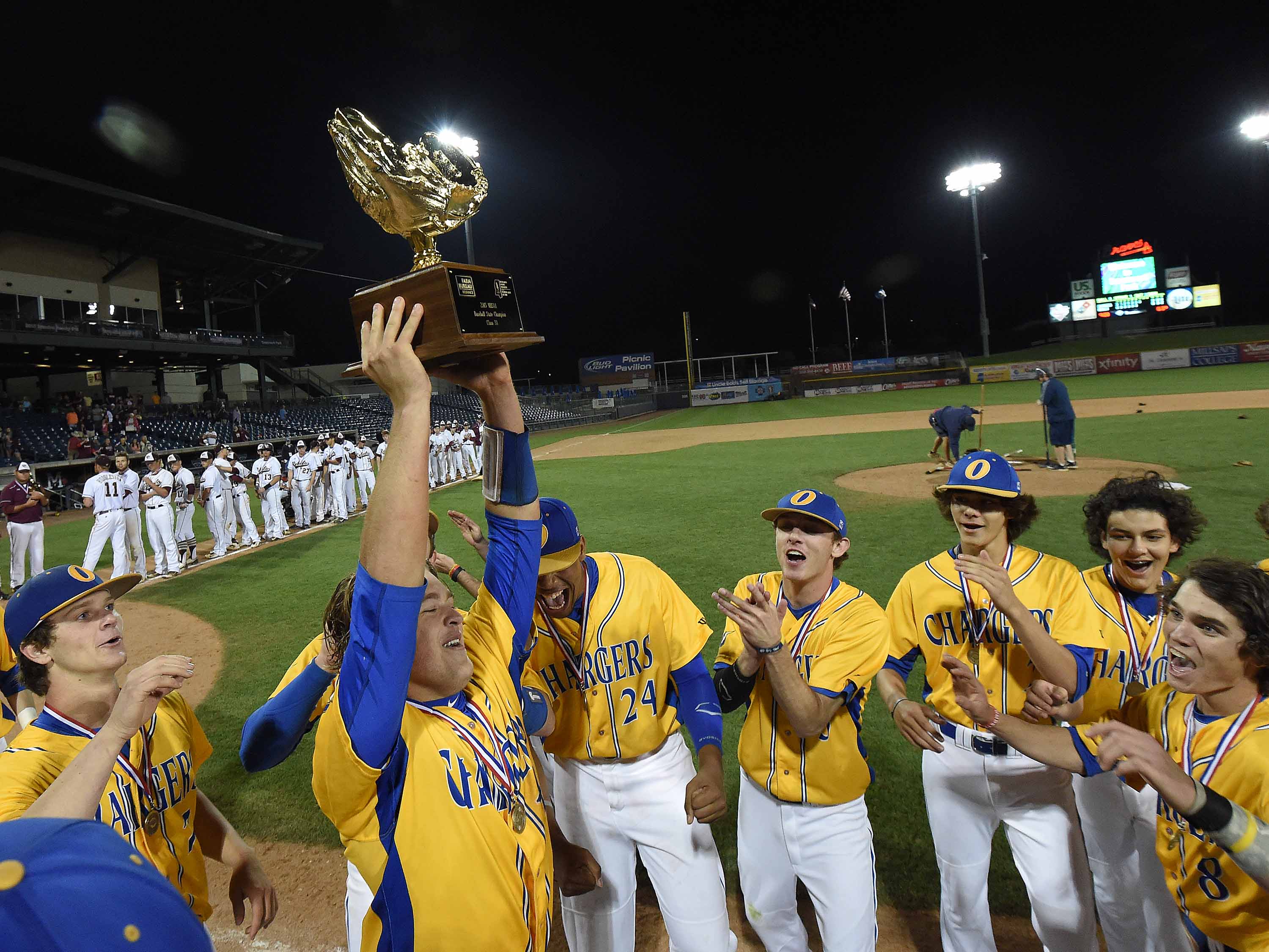 The Oxford Chargers celebrate with the Class 5A trophy after beating George County, 9-0, in Game 2 on Thursday in the MHSAA State Championship at Trustmark Park in Pearl.