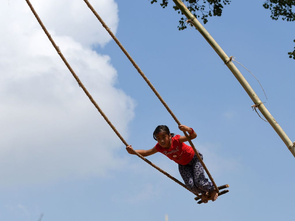 A child plays on a swing on the sixth day of the Hindu festival of Dashain in Lalitpur, on the outskirts of Kathmandu, Nepal. People of all ages play on a swings while marking the largest Hindu festival of Dashain in honour of the Hindu goddess of po