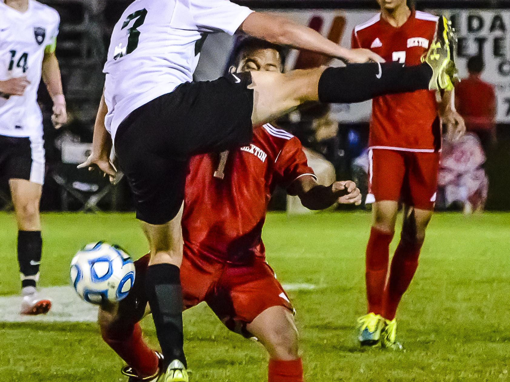 Nang Tuang ,right, of Sexton gets under Alex Scott of Williamston as Scott attempts to head the ball during their Division 3 District Semifinal game Wednesday. Scott would crash to the ground and Tuang would receive a yellow card.