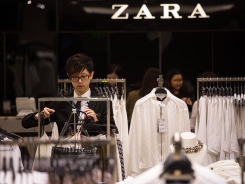 An employee arranges clothes at a Zara store, in Hong Kong, China, on ...
