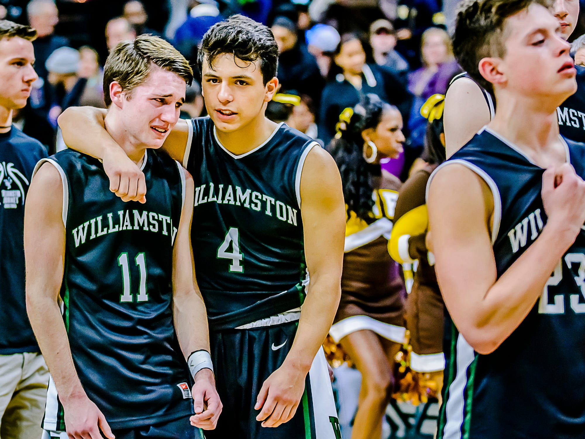 Sophomore Frankie Toomey ,4, of Williamston consoles senior Connor Porrell ,11, after their Class B state semifinal loss to Detroit Henry Ford Friday March 25, 2016 at the Breslin Center in East Lansing. KEVIN W. FOWLER PHOTO