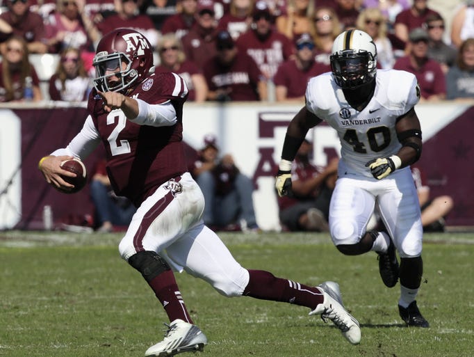 Johnny Manziel of the Texas A&amp;M Aggies looks for a receicver as he scrambles to Vanderbilt defenders at Kyle Field on Oct. 26 in College Station, Texas.
