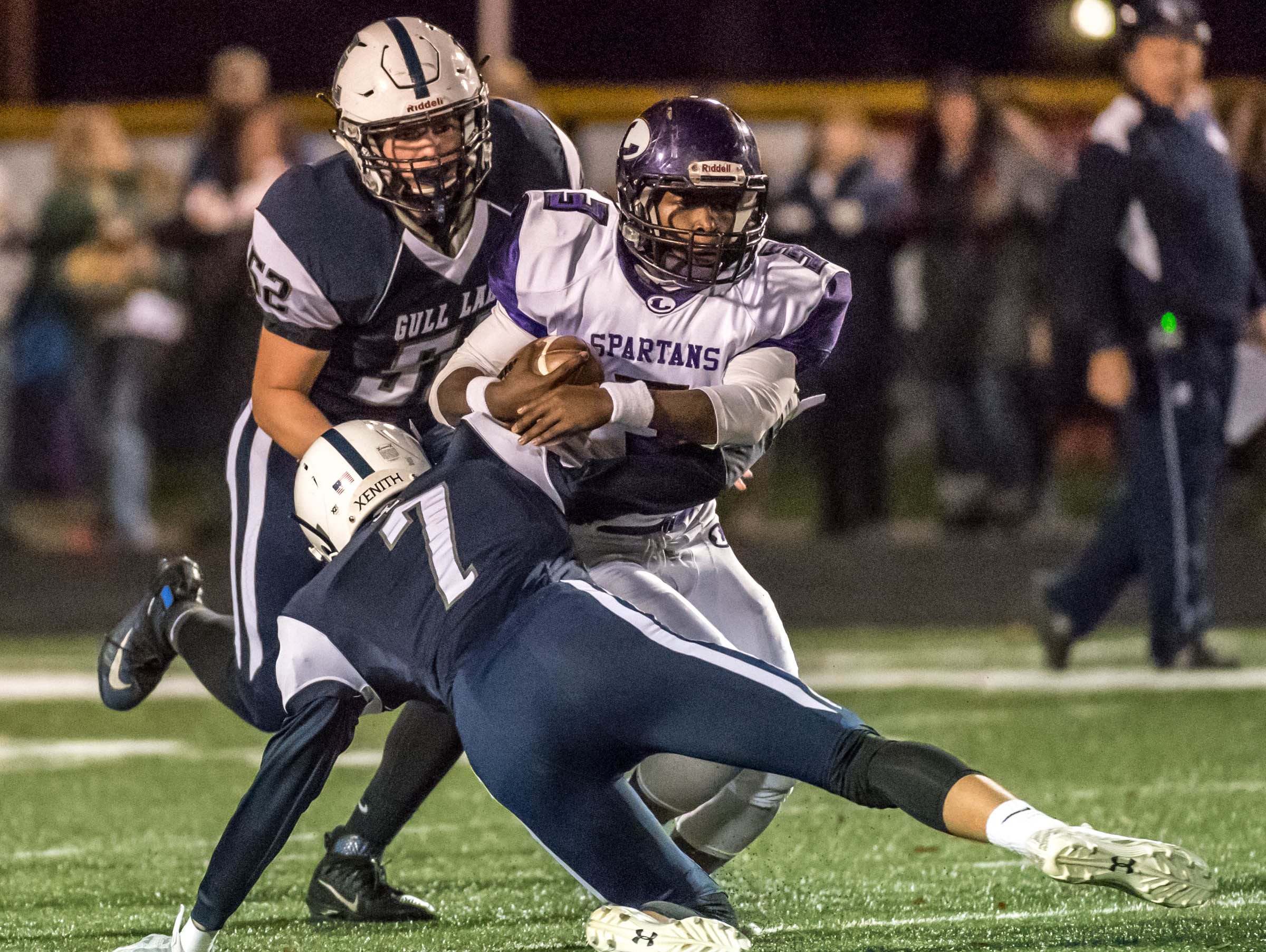 Gull Lake's Ryan McMullen (7) and Avery Eastman (52) bring down Lakeview's JayVion Settles (3) during first half action Friday evening.