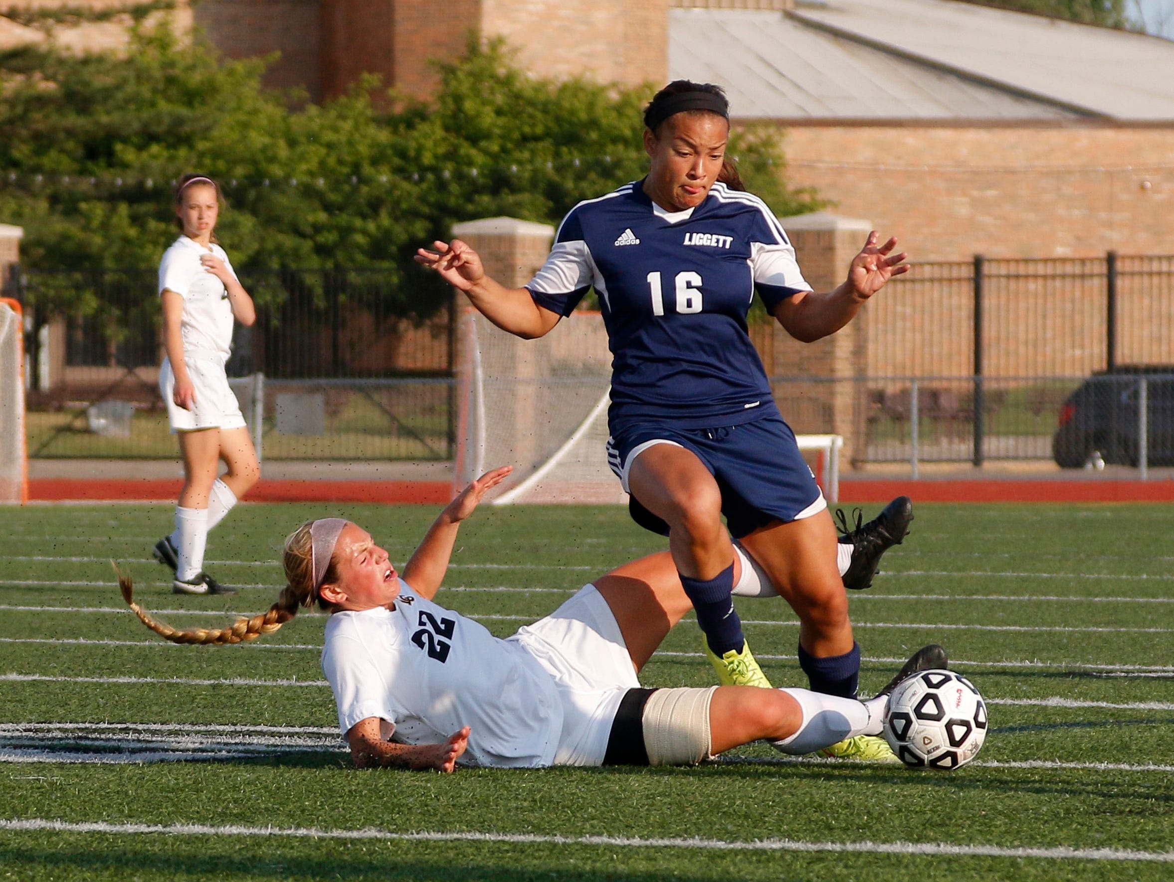 Lansing Christian's Abby Krueger, left, and University Liggett's Alexis Wenger battle for the ball during their MHSAA quarterfinal game Tuesday, June 14, 2016, at Troy Athens High School.