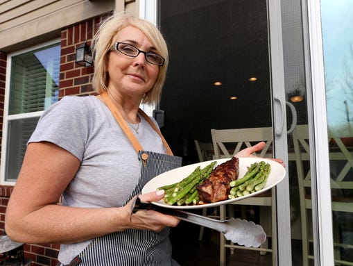 Lorraine Rates, 56, holds a plate with asparagus and