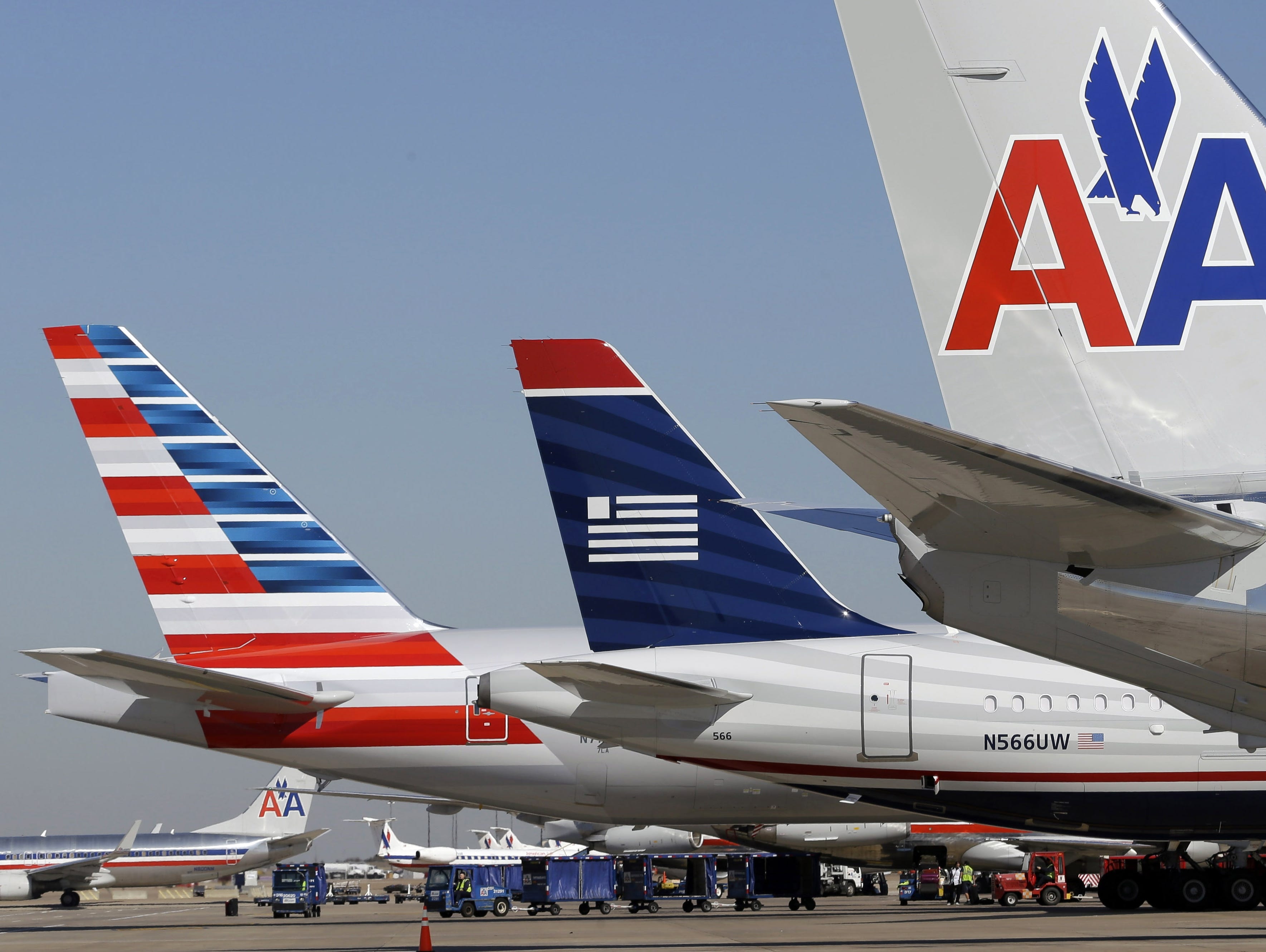 This file photo from Feb. 14, 2013, shows US Airways and American Airlines planes at Dallas/Fort Worth International Airport.