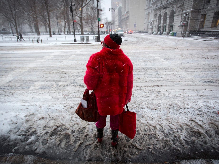 Prepared for the elements, a woman waits to cross Centre