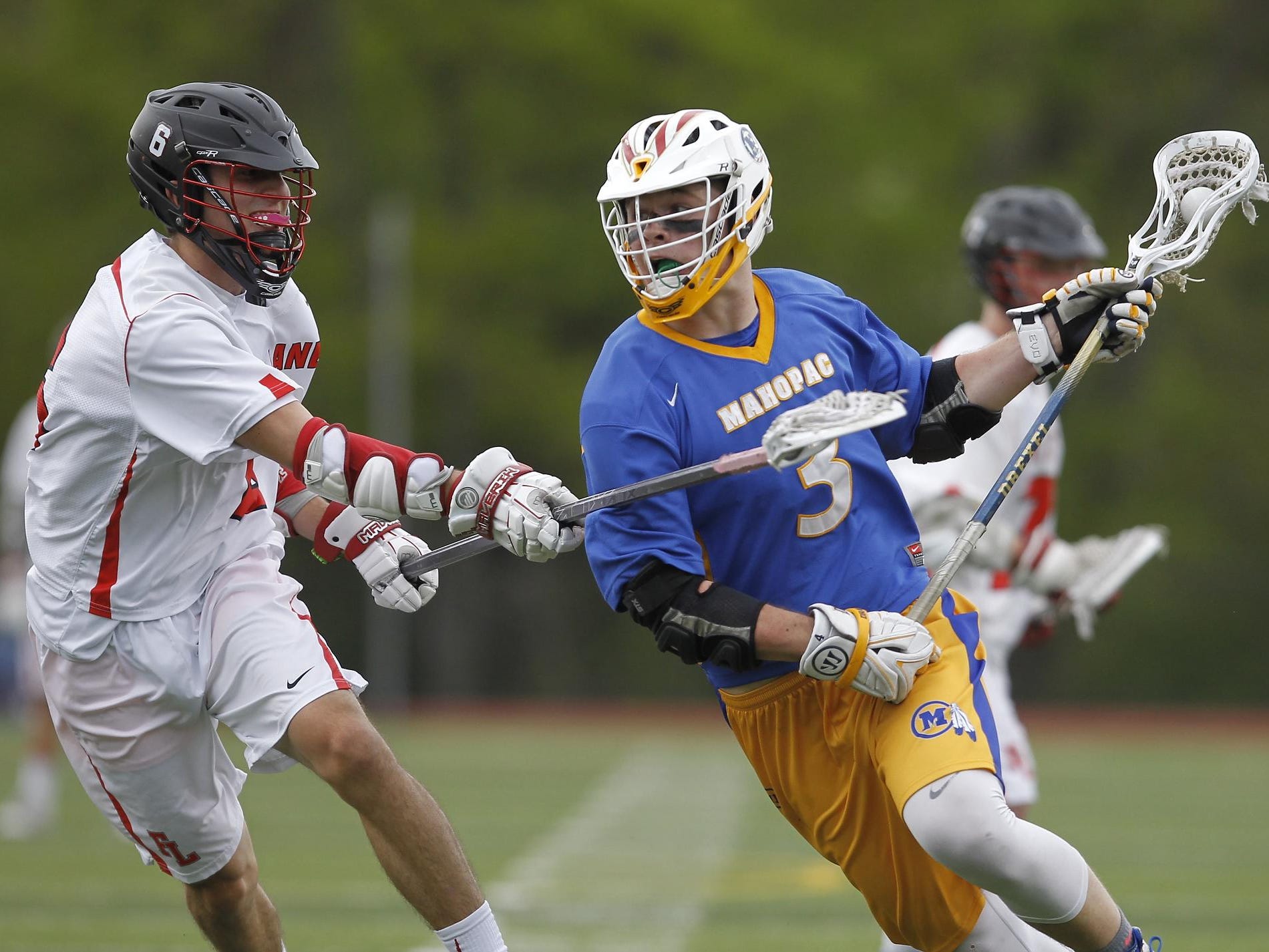 Mahopac’s Dan Foley works the ball against Fox Lane defenseman Sean New during a Class A quarterfinal at Fox Lane High School in Bedford on Wednesday. The Indians won 13-12.