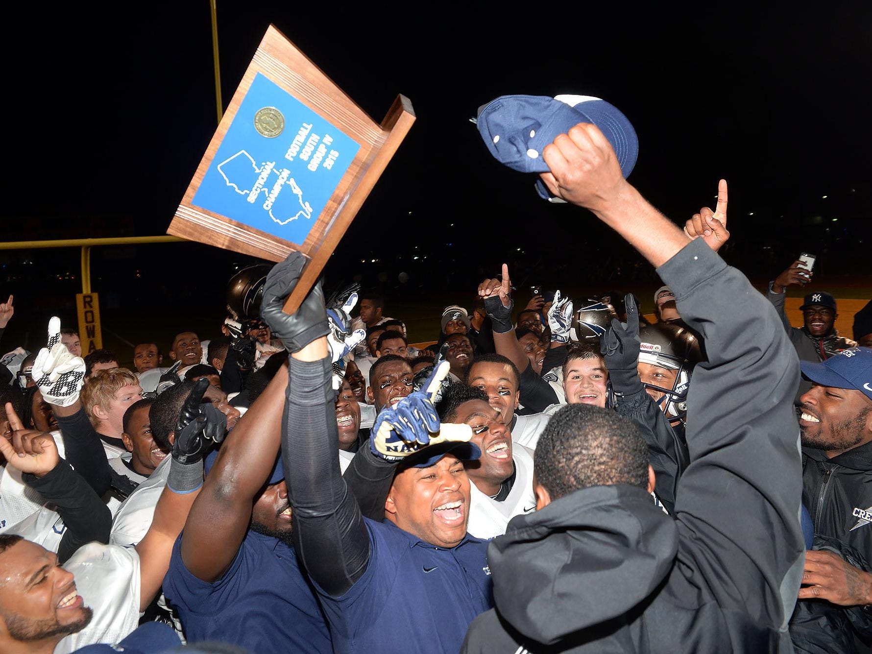 Timber Creek coach Rob Hinson (holding trophy) celebrates with his Chargers after their 28-24 win over Shawnee in the South Jersey Group 4 final on Sunday at Rowan.